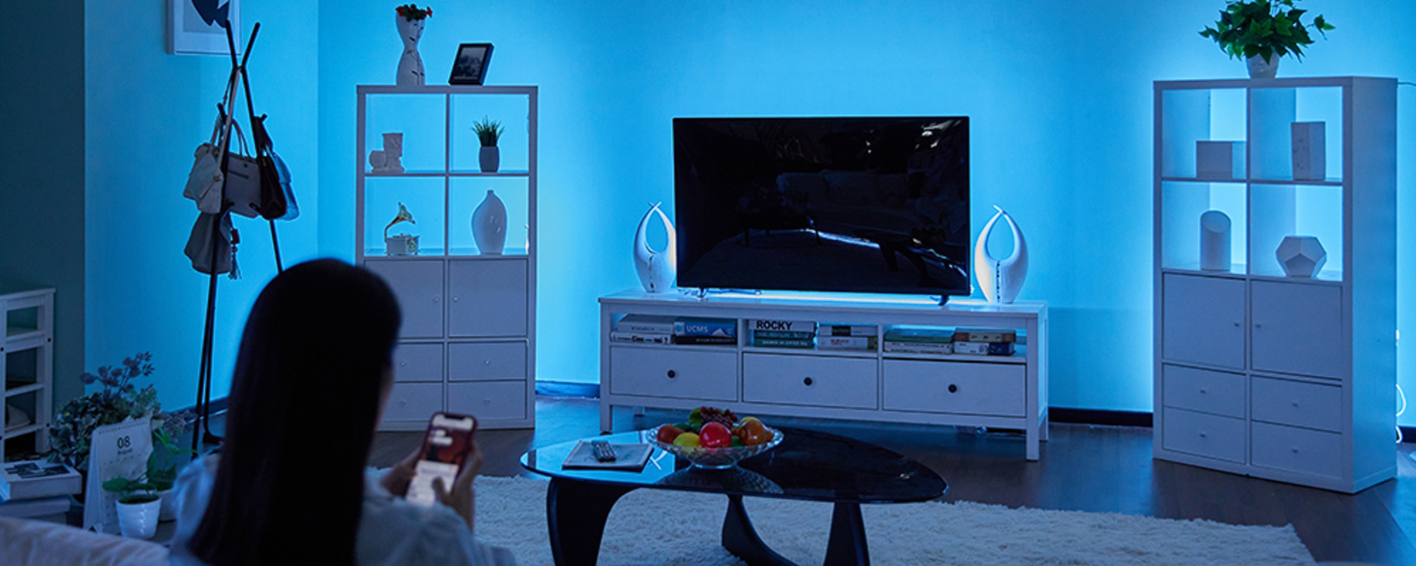 niebieskie podświetlenie ściany za szafkami i tv